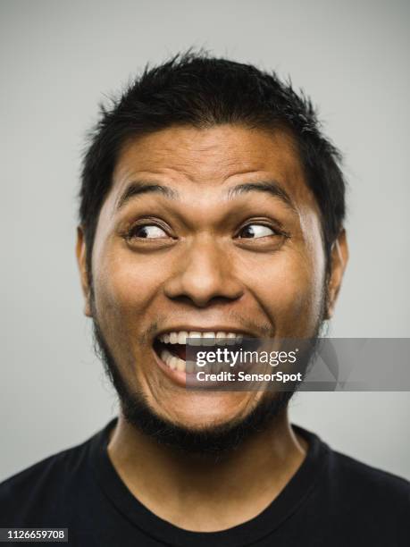 real malayo joven con expresión muy emocionada mirando a la cara - wow face man fotografías e imágenes de stock