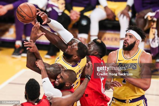 LeBron James of the Los Angeles Lakers fights for the rebound against Chris Paul and Clint Capela of the Houston Rockets during the first half at...