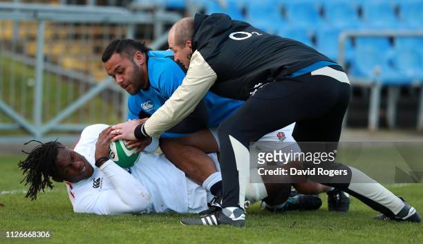 Maro Itoje is tackled by team mate Billy Vunipola and forwards coach Steve Borthwick during the England captain's run at UCD Sports Complex on...