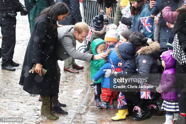 Meghan, Duchess of Sussex and Prince Harry, Duke of Sussex meet children in the crowd as they arrive at the Bristol Old Vic on February 01, 2019 in...