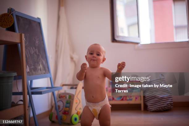 baby boy standing with a cookie - baby dancing stock-fotos und bilder