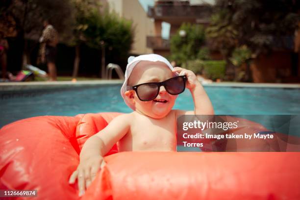 baby boy wearing sunglasses at the pool - baby-mischief stock pictures, royalty-free photos & images