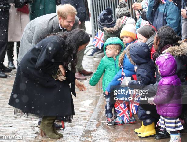 Meghan, Duchess of Sussex and Prince Harry, Duke of Sussex meet children in the crowd as they arrive at the Bristol Old Vic on February 01, 2019 in...