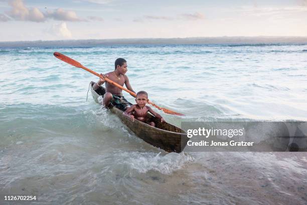 Local kids are playing with a canoe at Manus Island could have been a tourist destination. Crystal clear water, wreck from WWII, and friendly...