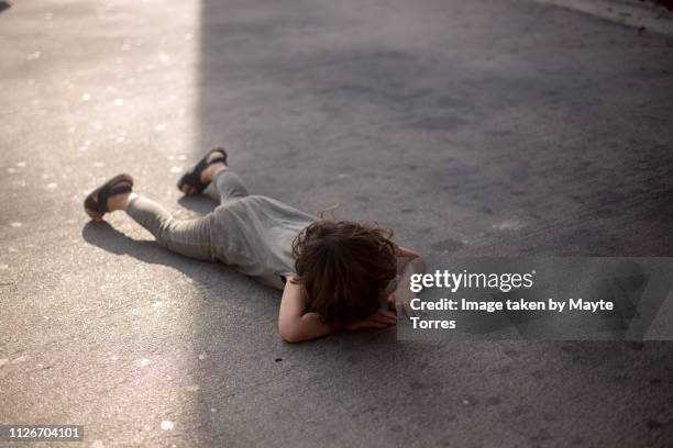toddler lying down on the floor having a meltdown - trotzanfall stock-fotos und bilder