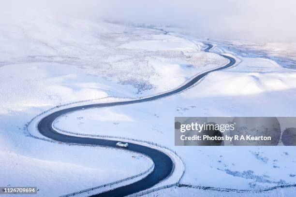 car driving a country road in beautiful winter landscape - s shape stock pictures, royalty-free photos & images