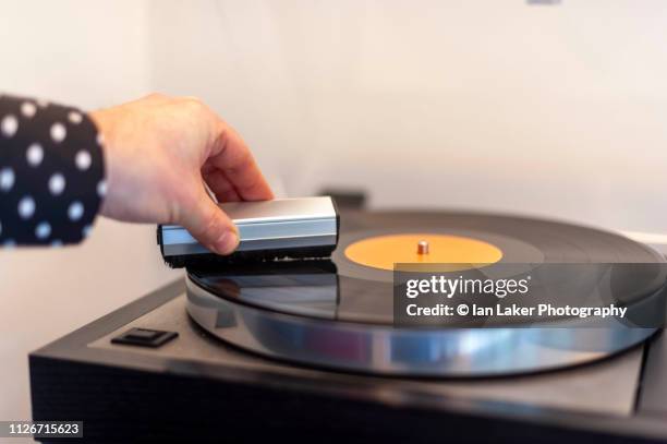 littlebourne, canterbury, england. 20 january 2019. vinyl record placed on turntable, being cleaned with carbon fibre brush - lp fotografías e imágenes de stock