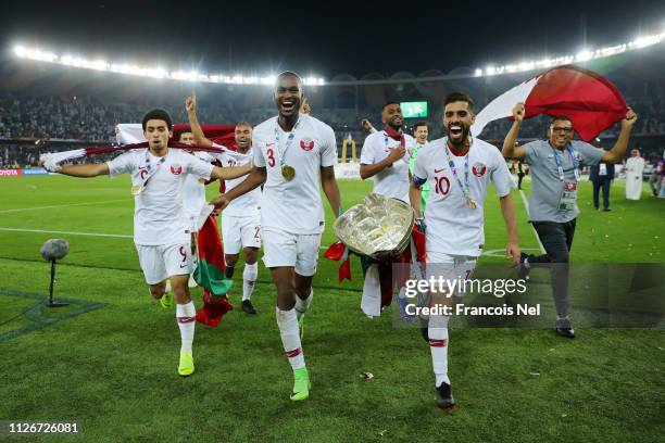 Khaled Mohammed, Abdelkarim Hassan and Hasan Al Haydos of Qatar celebrate with the AFC Asian Trophy following their sides victory in the AFC Asian...