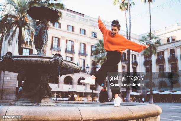niña de pie en puntillas a la fuente - calle barcelona fotografías e imágenes de stock