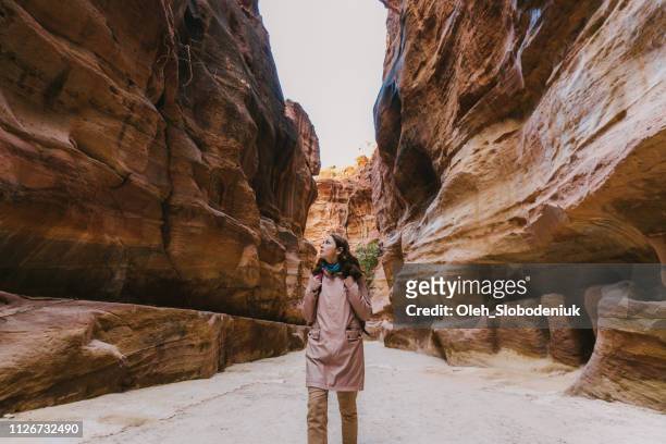 vrouw wandelen in siq canyon in petra - wonder stockfoto's en -beelden