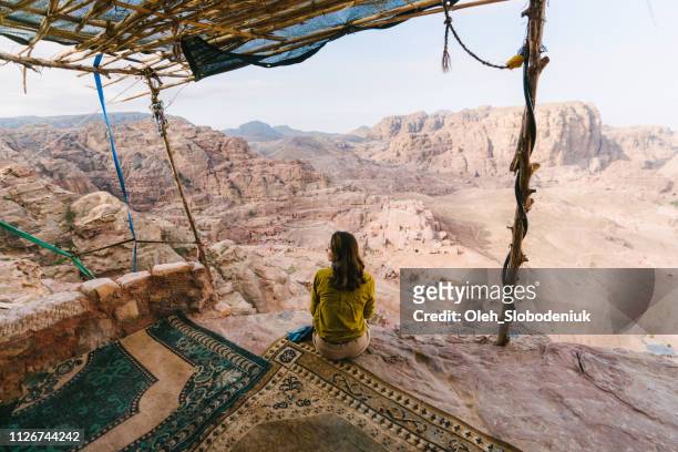 woman sitting and looking at view of desert in petra - west asia stock pictures, royalty-free photos & images