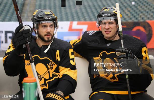 Kris Letang and Sidney Crosby of the Pittsburgh Penguins wait on the bench to practice at Lincoln Financial Field ahead of the 2019 Coors Light NHL...