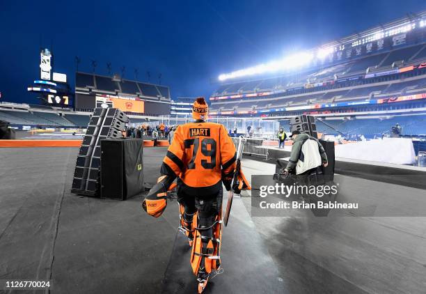 Goaltender Carter Hart of the Philadelphia Flyers walk on the field to practice for the 2019 Coors Light NHL Stadium Series game against the...