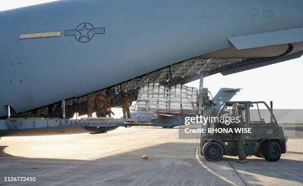 Military personnel load a C-17 cargo plane with food, water and medicine for a humanitarian mission to Colombia to aid Venezuelans at the Homestead...