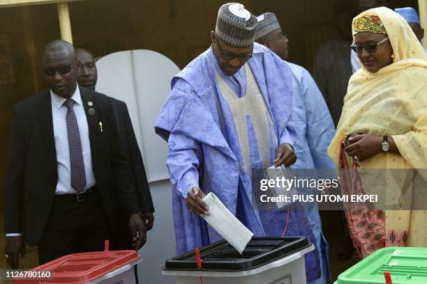 Candidate of the All Progressives Congress and incumbent President Muhammadu Buhari , flanked by his wife Aisha Buhari , casts his vote at a polling...