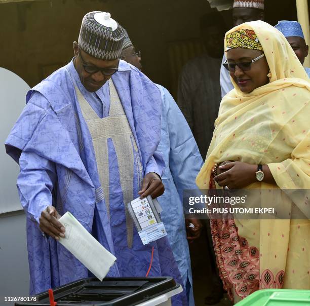 Candidate of the All Progressives Congress and incumbent President Muhammadu Buhari , flanked by his wife Aisha Buhari , casts his vote at a polling...