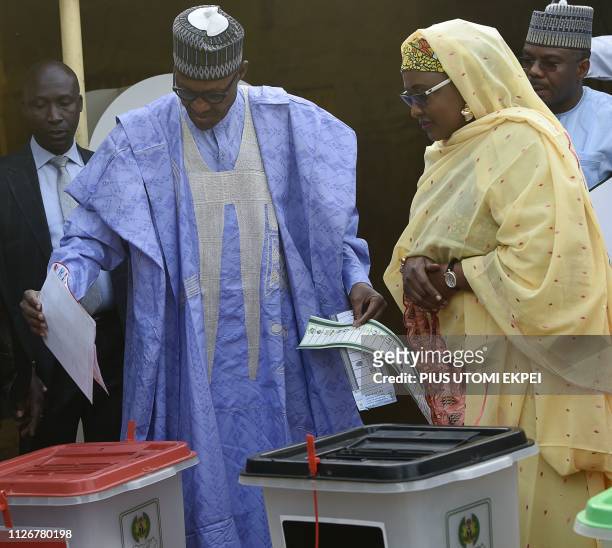 Candidate of the All Progressives Congress and incumbent President Muhammadu Buhari , flanked by his wife Aisha Buhari , casts his vote at a polling...