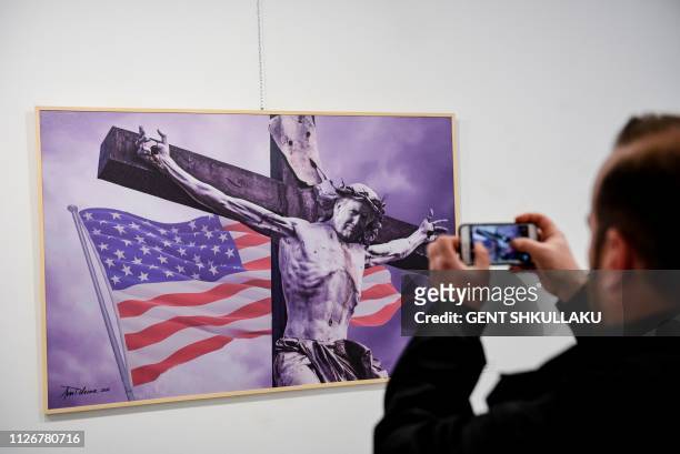 Visitor takes a picture of a painting by Albanian artist Avni Delvina during the exhibition 'The Donald' in Tirana on February 19, 2019. - Donald...
