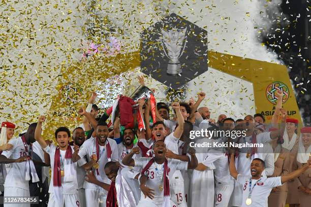Players of Qatar celebrates their victory as Hasan Al Haydos lifts the trophy after the AFC Asian Cup final match between Japan and Qatar at Zayed...
