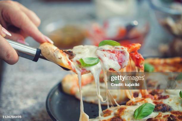 versgebakken homemade peperoni pizza - cheese pull stockfoto's en -beelden