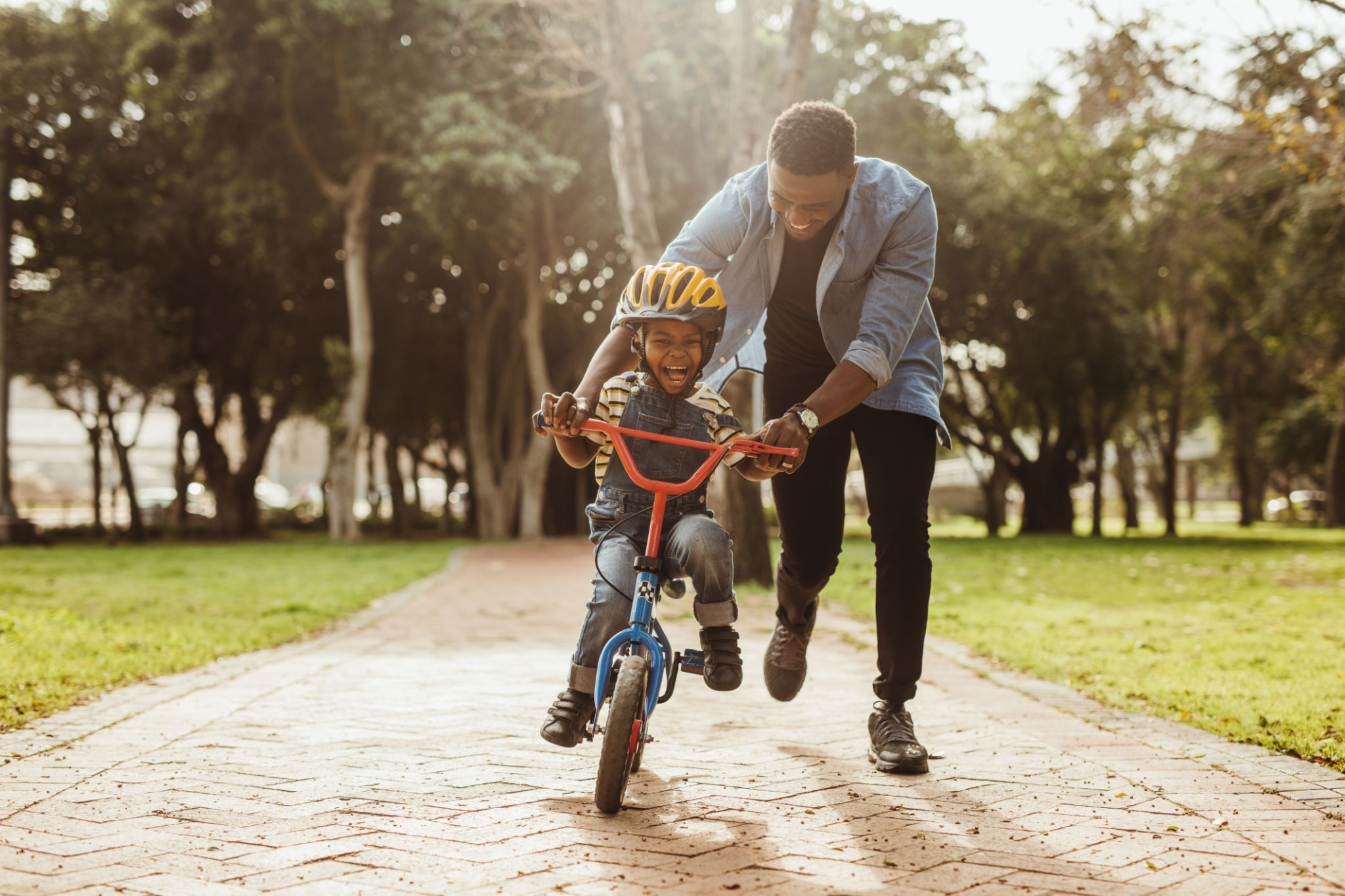 Father teaching his son cycling at park Father teaching his son cycling at park