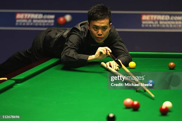 Marco Fu of Hong Kong in action during the round one game against Martin Gould of England on day five of the Betfred.com World Snooker Championship...