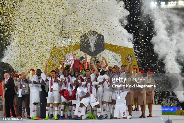 Players of Qatar celebrates their victory as Hasan Al Haydos lifts the trophy after the AFC Asian Cup final match between Japan and Qatar at Zayed...