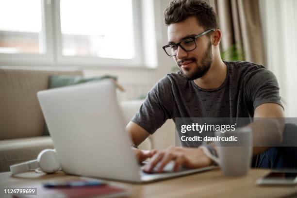 teenage boy using laptop at home - college males stock pictures, royalty-free photos & images