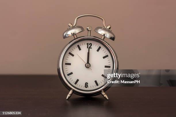 alarm clock set at noon - mittag stock-fotos und bilder