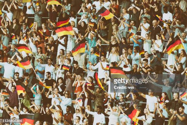 deutschland-fans schwenkten ihre fahnen auf einem stadion - germany football stock-fotos und bilder