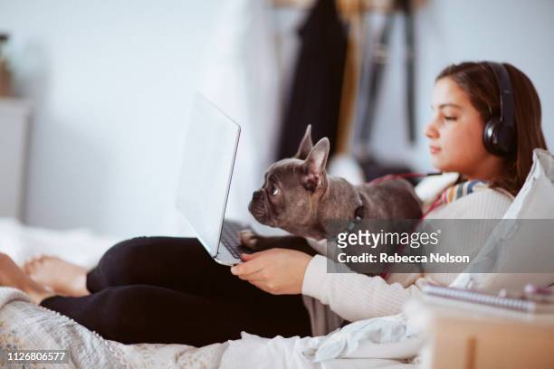 girl with headphones using computer in her bedroom