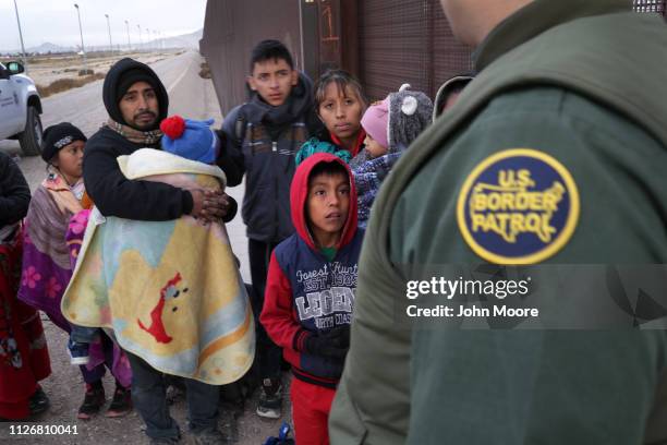 Border Patrol agent speaks with Central American immigrants at the U.S.-Mexico border fence on February 01, 2019 in El Paso, Texas. The migrants were...