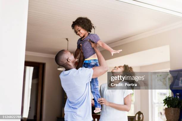 woman looking at man picking up son in house - pretending to be a plane stock pictures, royalty-free photos & images