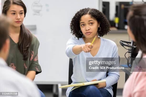 teen mädchen nimmt frage während der schweren high-school-studiengruppe - girl pointing stock-fotos und bilder