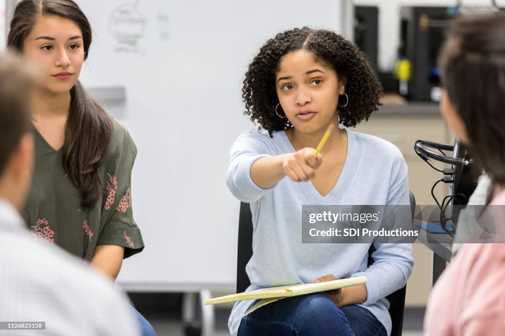 Teen girl takes question during serious high school study group