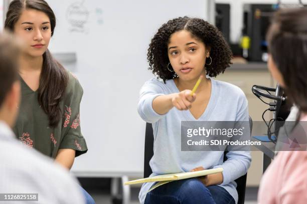 teen girl takes question during serious high school study group - university debate stock pictures, royalty-free photos & images