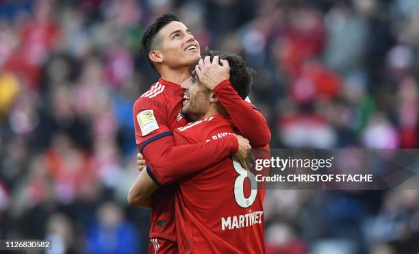 Bayern Munich's Colombian James Rodriguez congratulates Spanish midfielder Javi Martinez after he scored during the German first division Bundesliga...