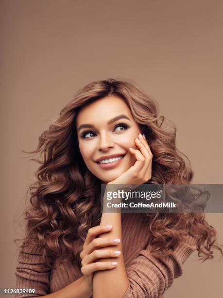 brown haired woman with curly hairstyle - long hair stock pictures, royalty-free photos & images