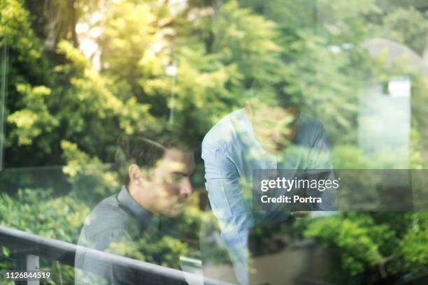 zakenlieden met behulp van computer gezien via window - job seekers outside the ministry of labor employment ahead of job creation figures stockfoto's en -beelden