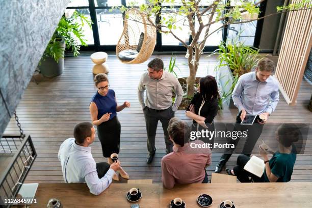 business people communicating in cafe - cafe meeting stock pictures, royalty-free photos & images