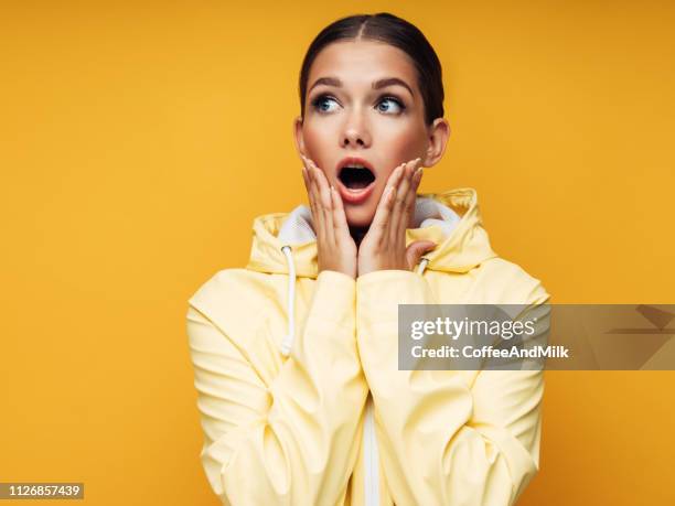 woman in a raincoat - beautiful woman shocked stock pictures, royalty-free photos & images