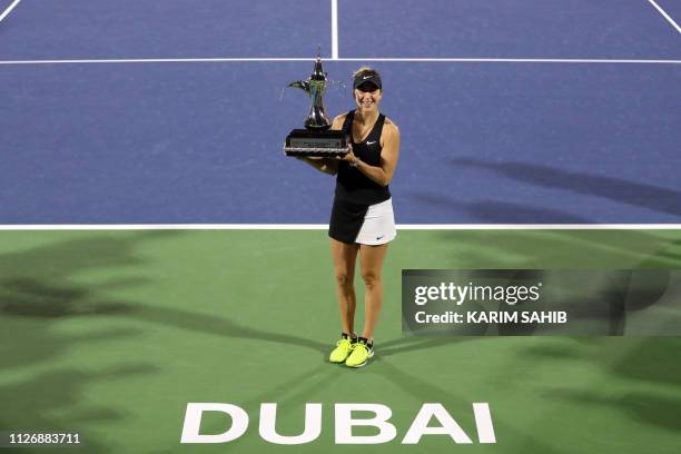 Belinda Bencic of Switzerland poses with the trophy after winning the final of the WTA Dubai Duty Free Tennis Championship in the Gulf emirate of...