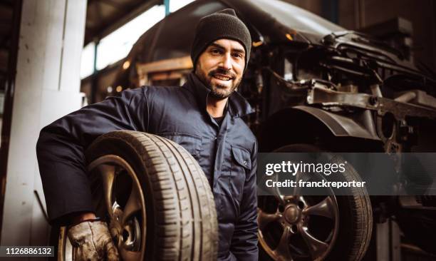 mechanic man repair a tire - auto mechanic stock pictures, royalty-free photos & images