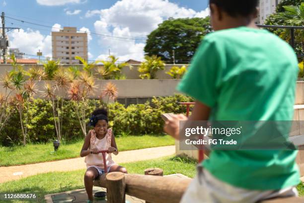 feliz irmão brincar de gangorra na teeterboard - seesaw - fotografias e filmes do acervo