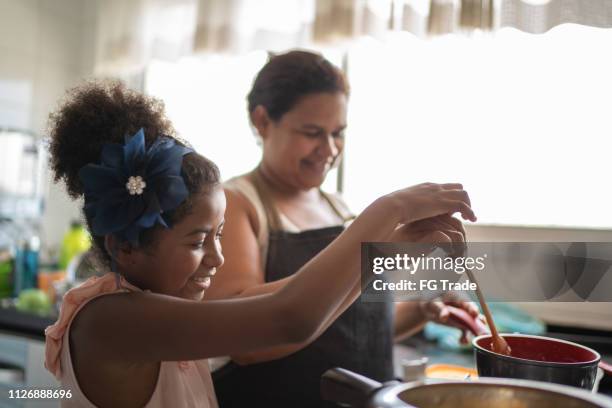 かわいい男の子は、彼女の母親の料理 - brazilian children ストックフォトと画像