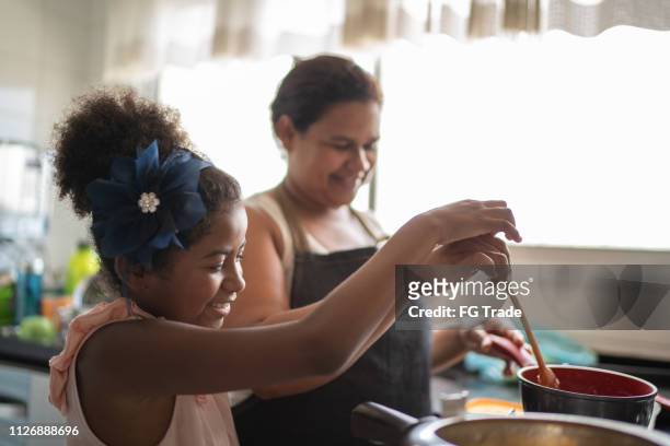 young girl cooking with her mother - brazilian culture stock pictures, royalty-free photos & images