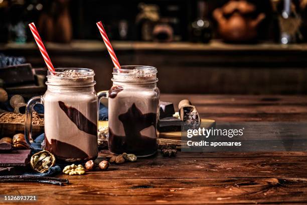 low key chocolate smoothies on a table in a rustic kitchen - smoothie stock pictures, royalty-free photos & images