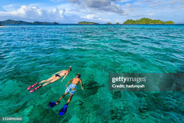 young couple snorkeling on east china sea, philippines - palawan philippines stock pictures, royalty-free photos & images