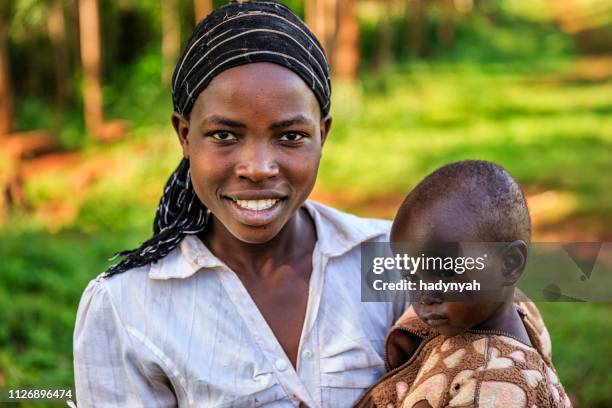 mujer africana joven sosteniendo a su bebé, kenia, áfrica - kenia fotografías e imágenes de stock