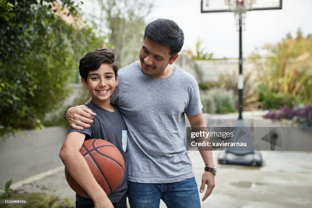 Portrait of happy boy and father with basketball